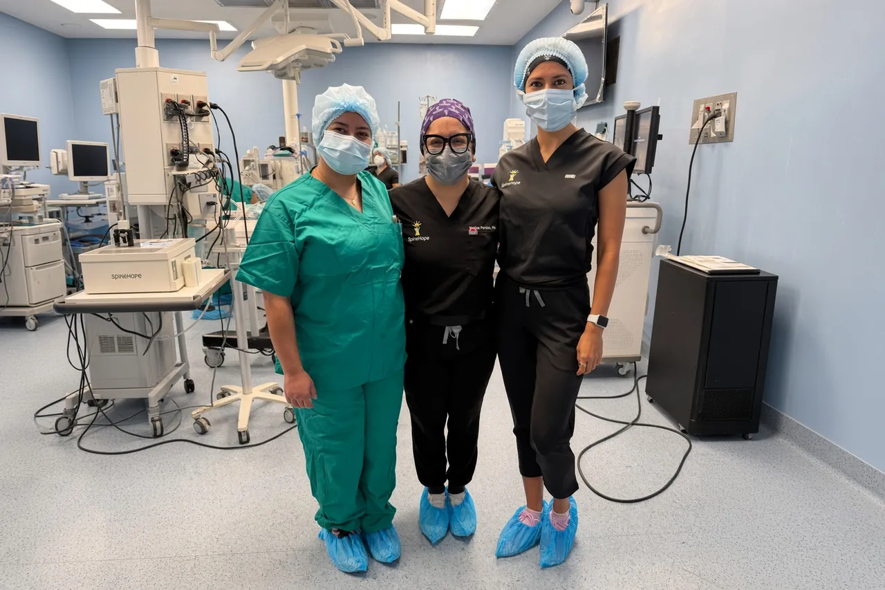 Three SpineHope clinicians in scrubs in an operating room