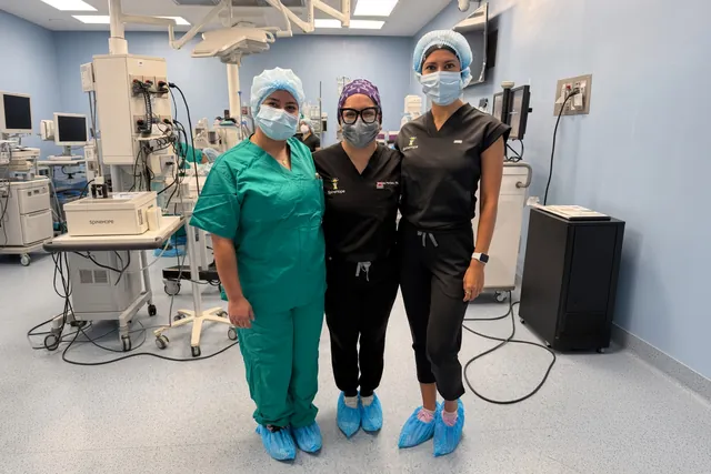 Three SpineHope clinicians in scrubs in an operating room