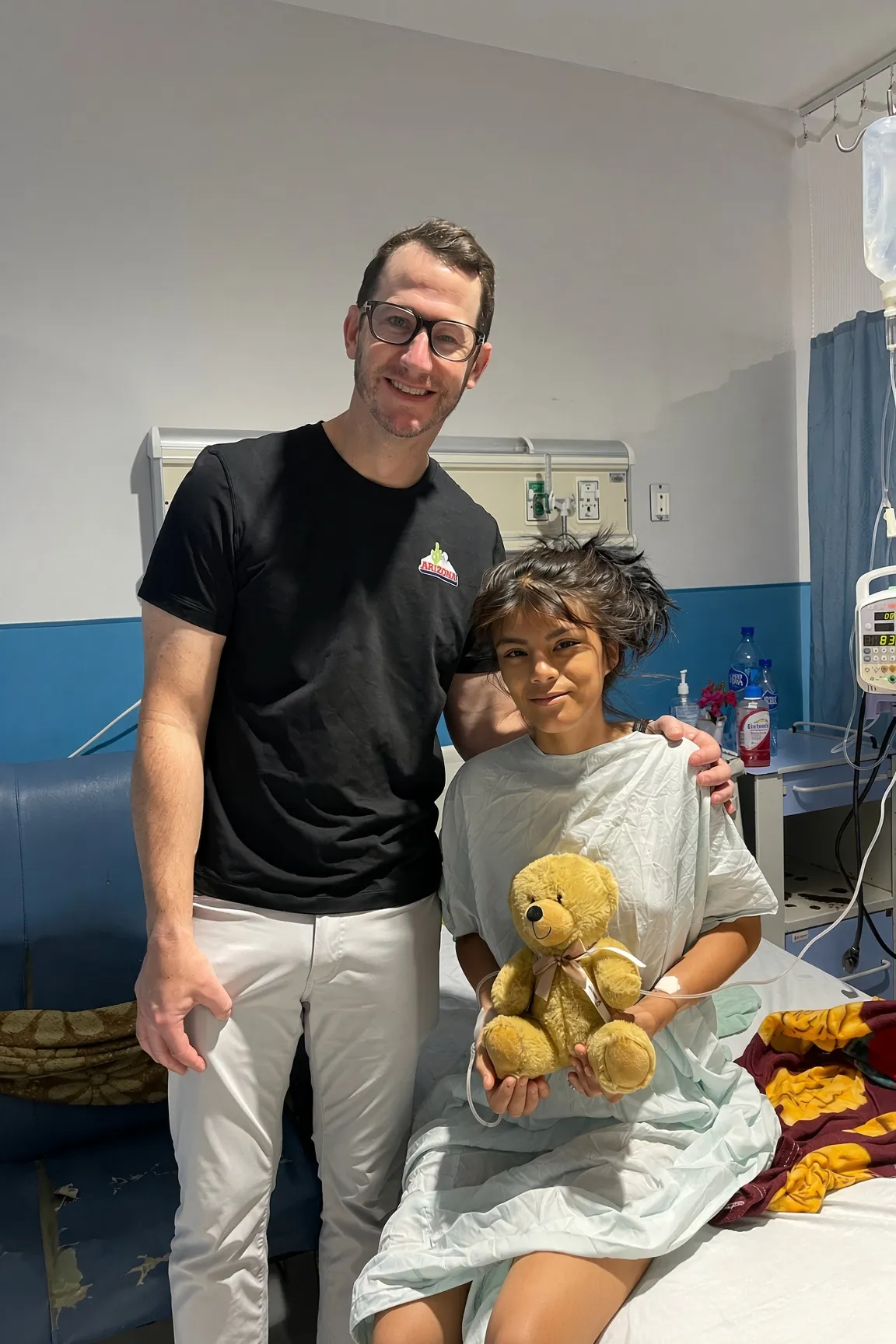 A SpineHope doctor with a young patient holding a teddy bear