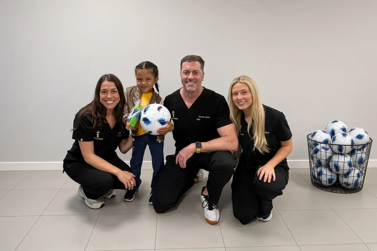 The SpineHope team with a young patient and soccer balls