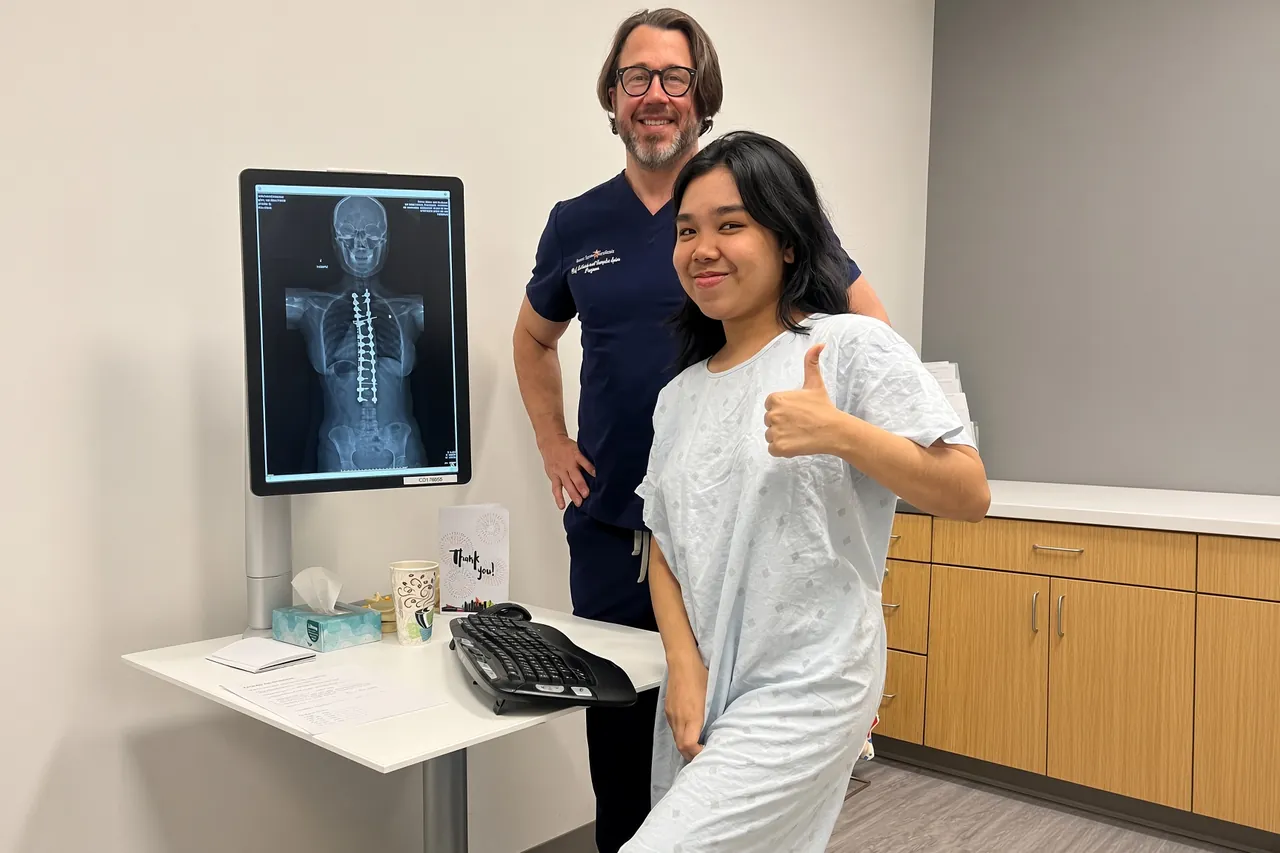 A SpineHope patient with her doctor and her spine X-ray