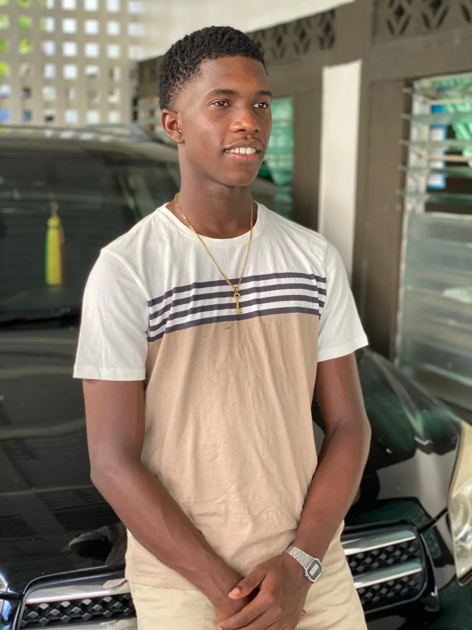 Rahsaan today, smiling, standing in front of a car